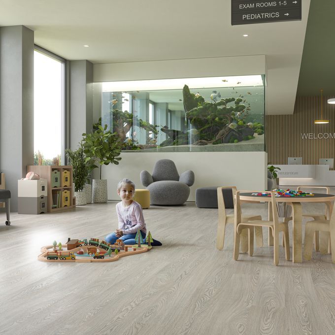 Oak effect flooring laid in a hospital waiting area with a child playing with toys