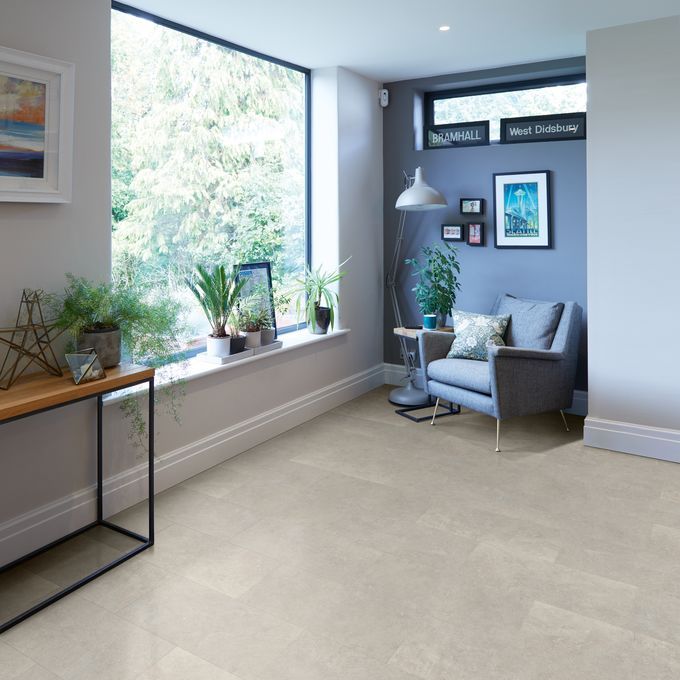 Cement effect flooring laid in a spacious seating area with a large window