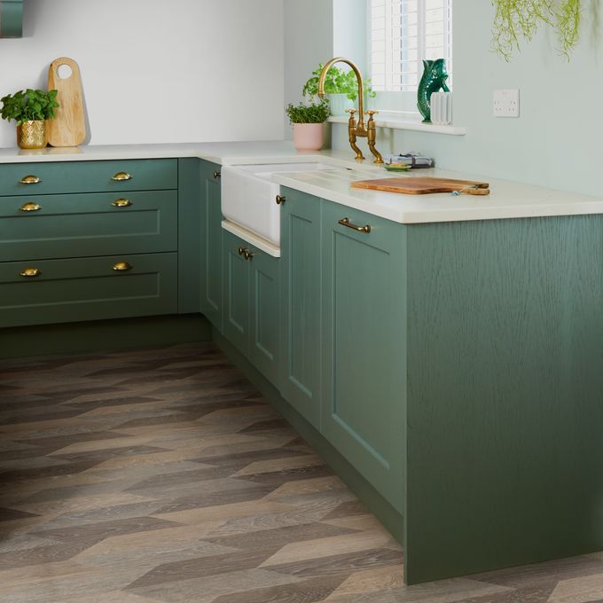 Oak effect patterned flooring laid in a kitchen with sage coloured units