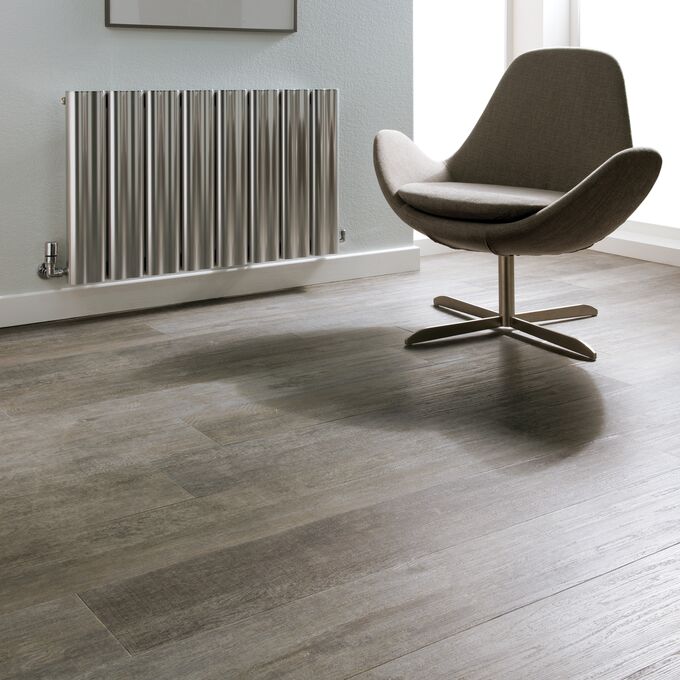 Silvered driftwood effect flooring laid in a room with a chair