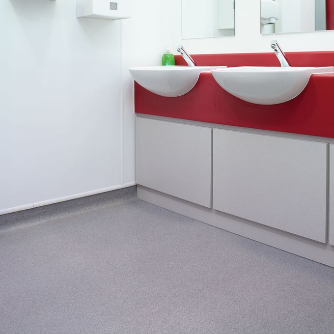 Grey stone effect safety flooring in hospital bathroom 