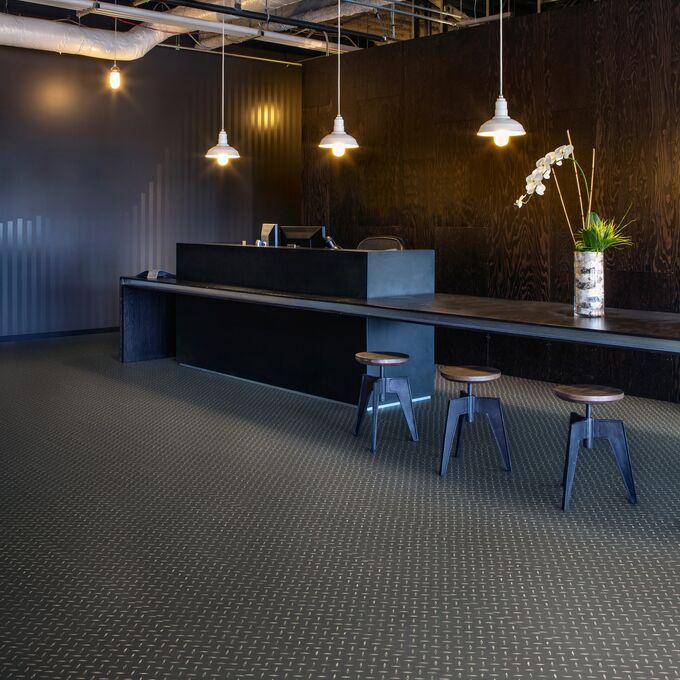 Black treadplate effect flooring in a dark reception area