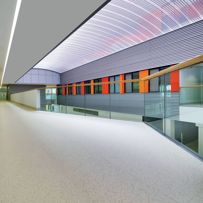 Upstairs corridor in a large building with neutral coloured flooring