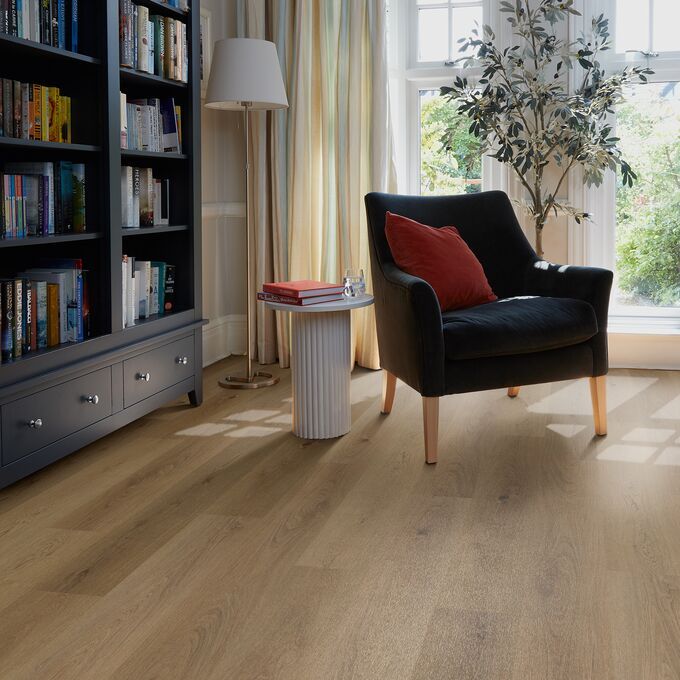 Oak effect flooring straight laid in a room with a bookcase and armchair