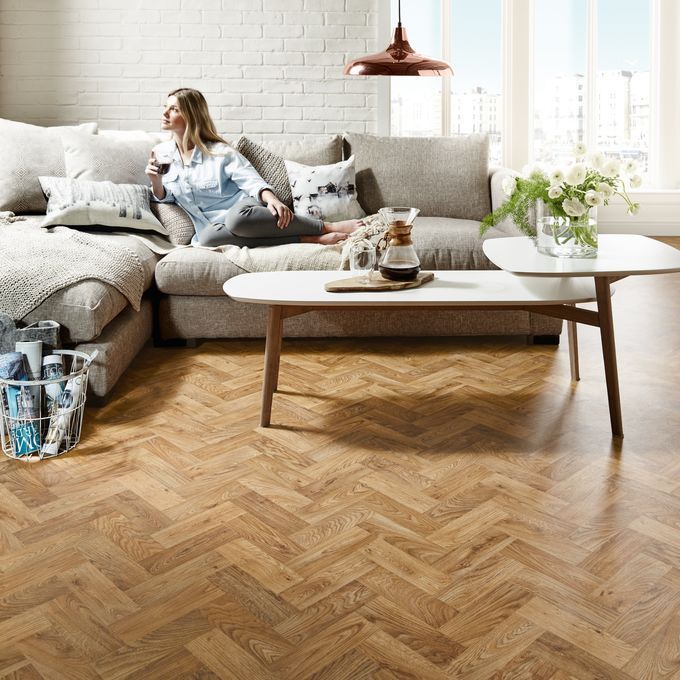 Oak parquet wood effect flooring in living room with a cream sofa and coffee table