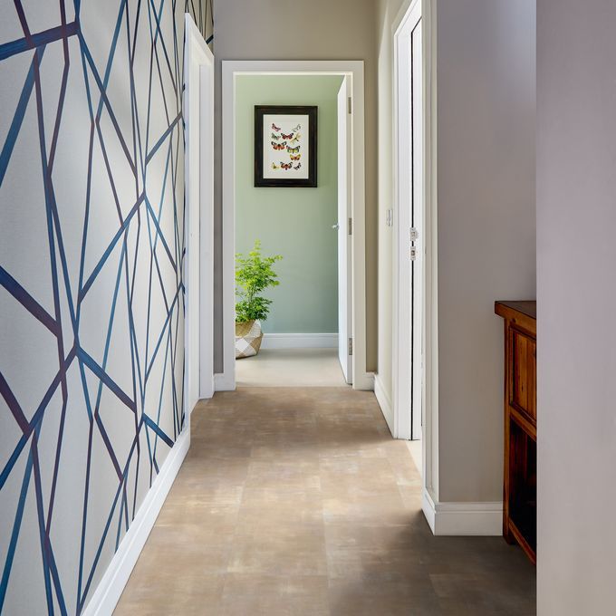 Light stone effect flooring in a hallway with a feature wall with geometric wallpaper 
