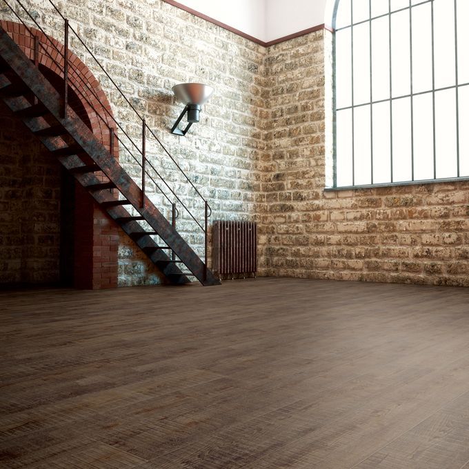 Large room with open brick walls featuring dark brown wood effect flooring