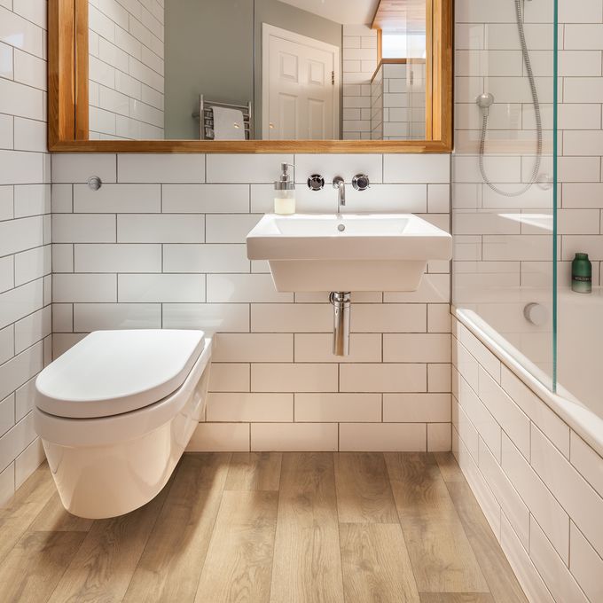 Light oak wood effect flooring in a modern style bathroom 